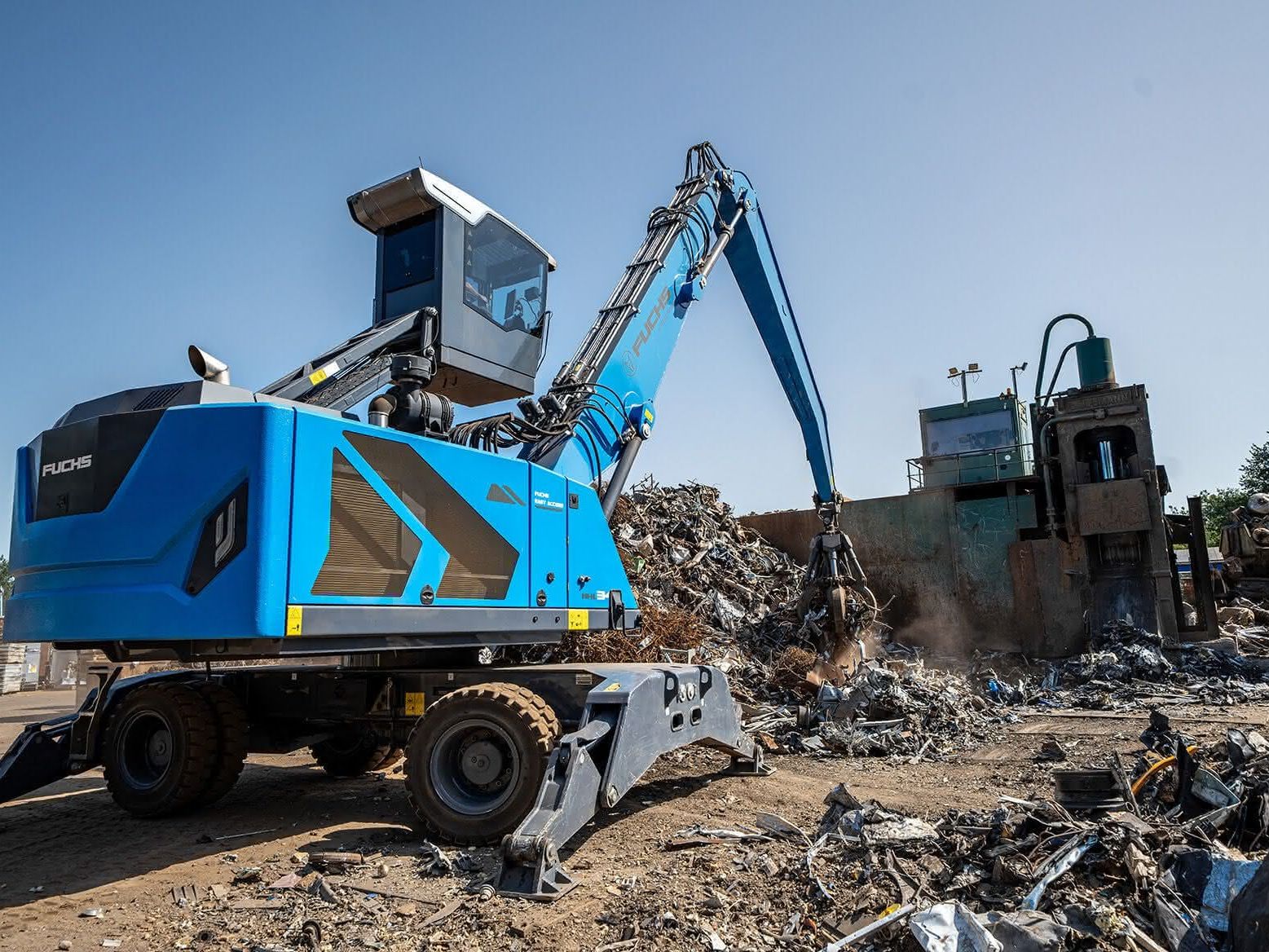 Ein blauer Fuchs Bagger Ein blauer Fuchs Bagger, der mit sienem Schalengreifer Schrott sortiert