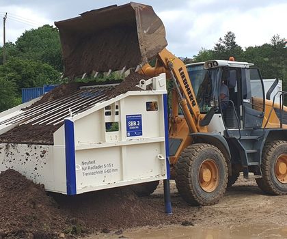 Ein Radlader von Liebherr belädt eine Siebanlage SBR3 von EAG mit Material