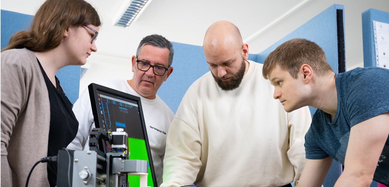 Prof. Campos trainiert mit den Studierenden im Labor. Prof. Campos trainiert mit den Studierenden Hannah Wieser, Sven Wroblewski und Dominik Heinz die Seitenkanalanalyse und verwendet dafür einen RISC-V Prozessor – einen Mikrocontroller. Dabei kommt auch ein Oszilloskop zum Einsatz, das elektronische Signale grafisch darstellt.