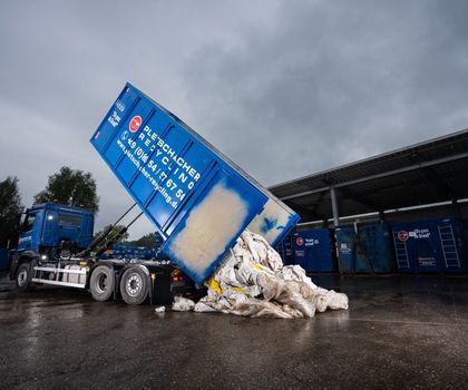 Palfinger-Abrollkipper Einer der Palfinger-Abrollkipper lädt Recyclingmaterial ab