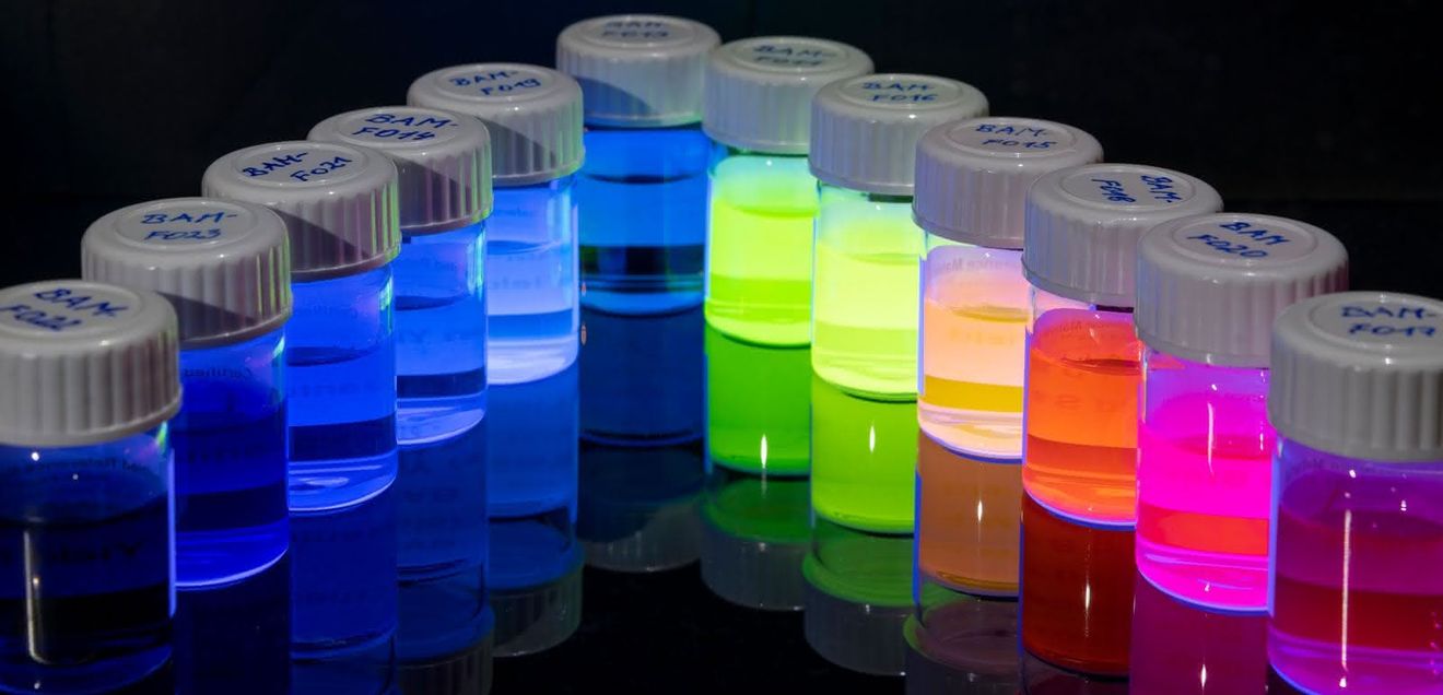 Standards für die Oberflächenanalyse von Nanopartikeln Im Projekt werden u.a. optisch aktive Nanopartikel untersucht. Hier als Symbolbild: bunt gefüllte Gläschen.