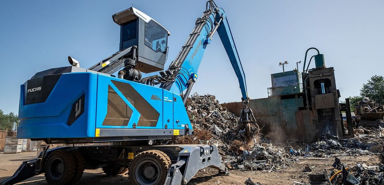 Ein blauer Fuchs Bagger Ein blauer Fuchs Bagger, der mit sienem Schalengreifer Schrott sortiert