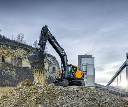 Ein Hyundai Bagger auf einem Werksgelände lädt Schutt ab