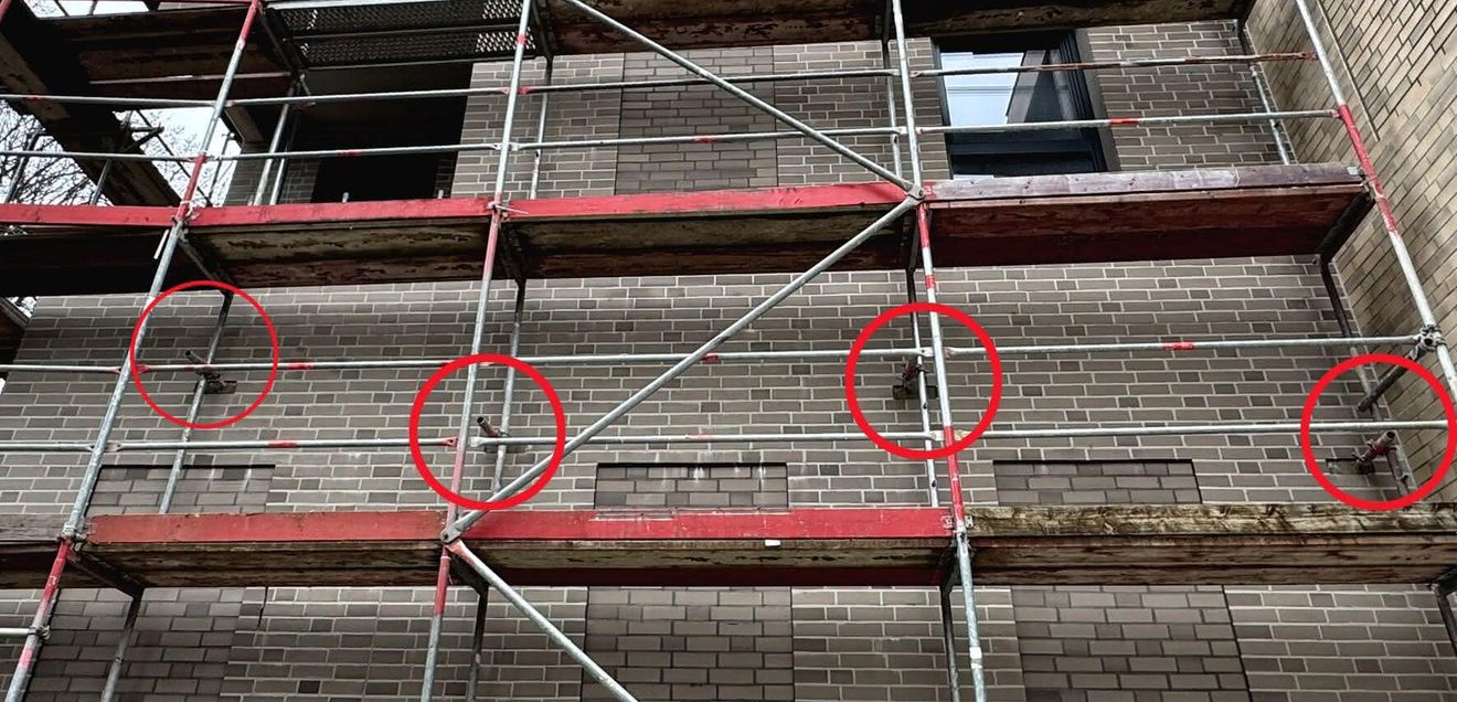 Isorocket Eine eingerüstete Hausfassade mit Mauerankern von Isorocket