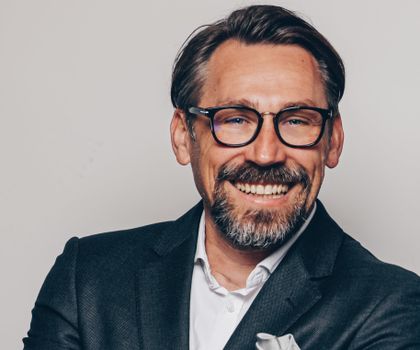 Roland Gisinger, Geschäftsführer der HW BAUFI Finanzgruppe lächelt in die Kamera