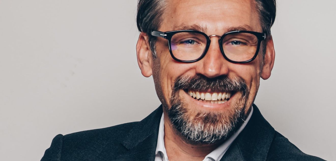 Roland Gisinger, Geschäftsführer der HW BAUFI Finanzgruppe lächelt in die Kamera