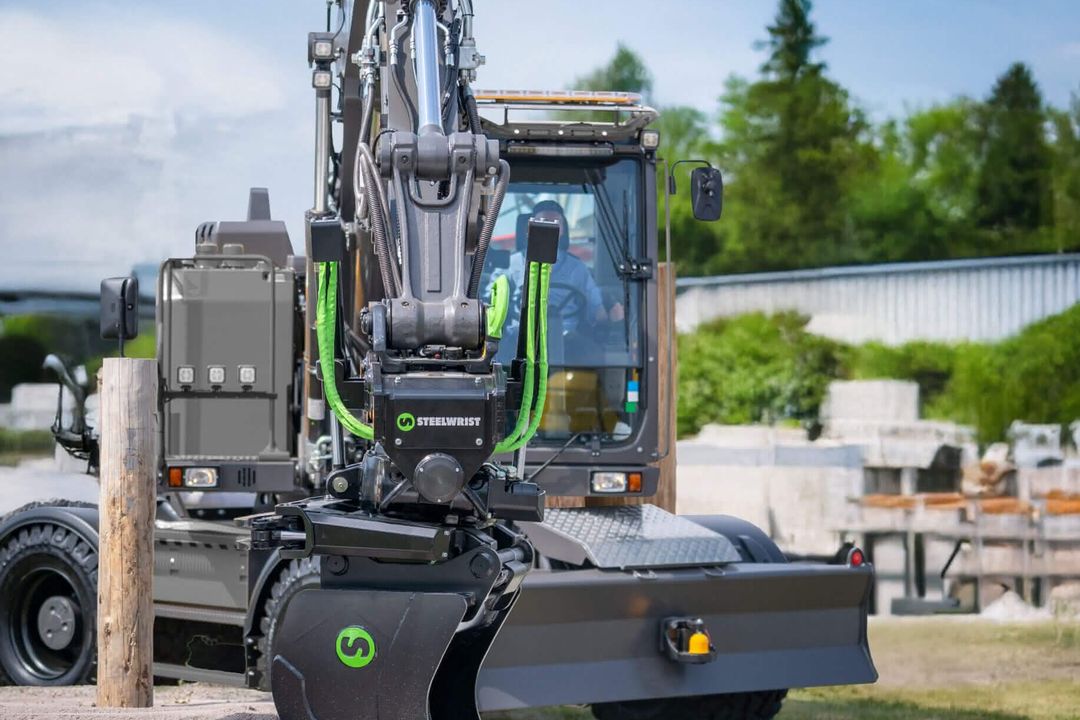 Ein Radbagger hält den neuen Tiltrotator von Steelwrist in die Kamera