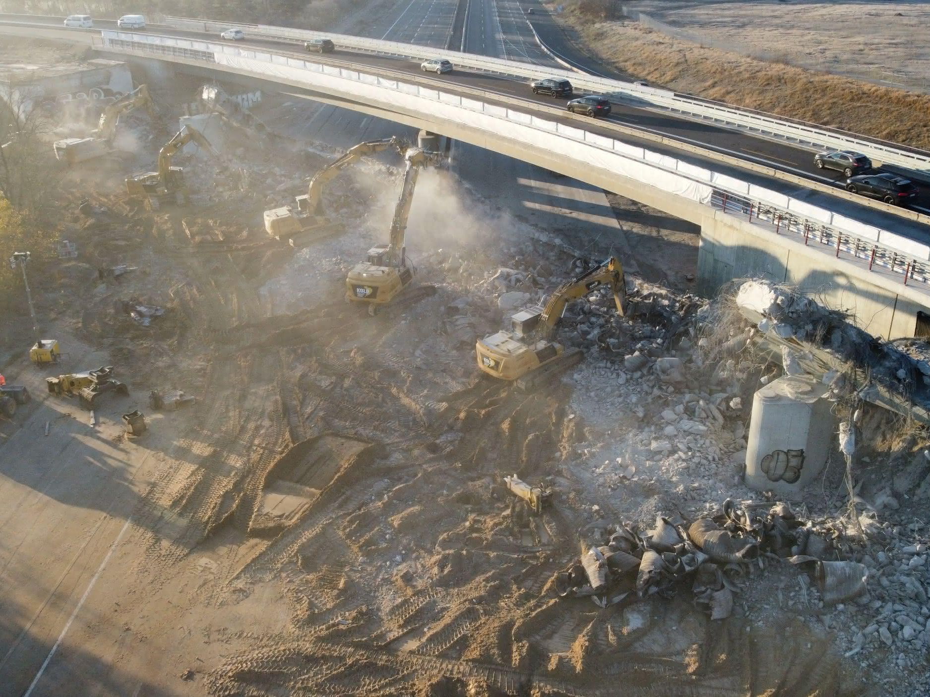 Die Cat-Maschinen brechen unter starkt Staubentwicklung eine große Brücke ab