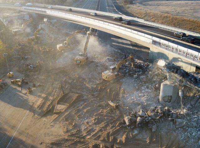 Die Cat-Maschinen brechen unter starkt Staubentwicklung eine große Brücke ab