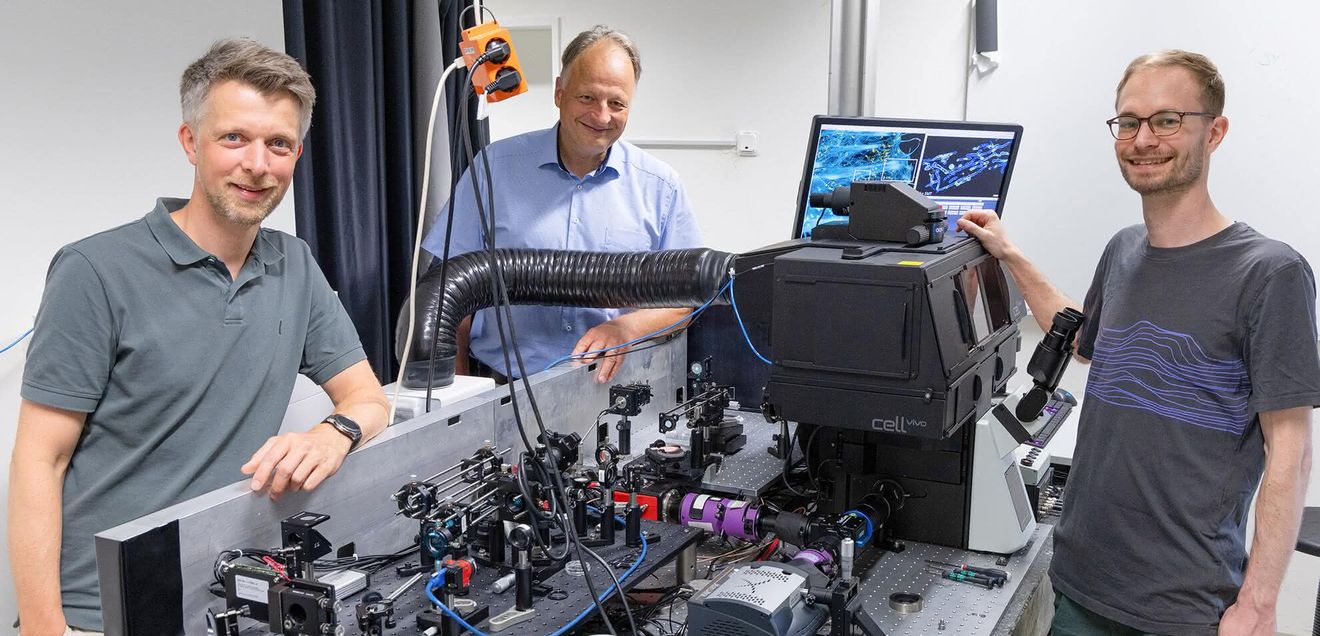 Dr. Rainer Kurre, Prof. Dr. Jacob Piehler und Doktorand Hauke Winkelmann Dr. Rainer Kurre, Prof. Dr. Jacob Piehler und Doktorand Hauke Winkelmann vor dem Fluoreszenzmikroskop im Zentrum für Zelluläre Nanoanalytik