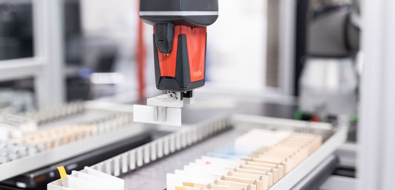 Der Roboterarm entnimmt die Proben aus dem Reservoir und stellt sie für die Messung bereit. Nach der Messung wird die Probe in einem anderen Magazin abgelegt.