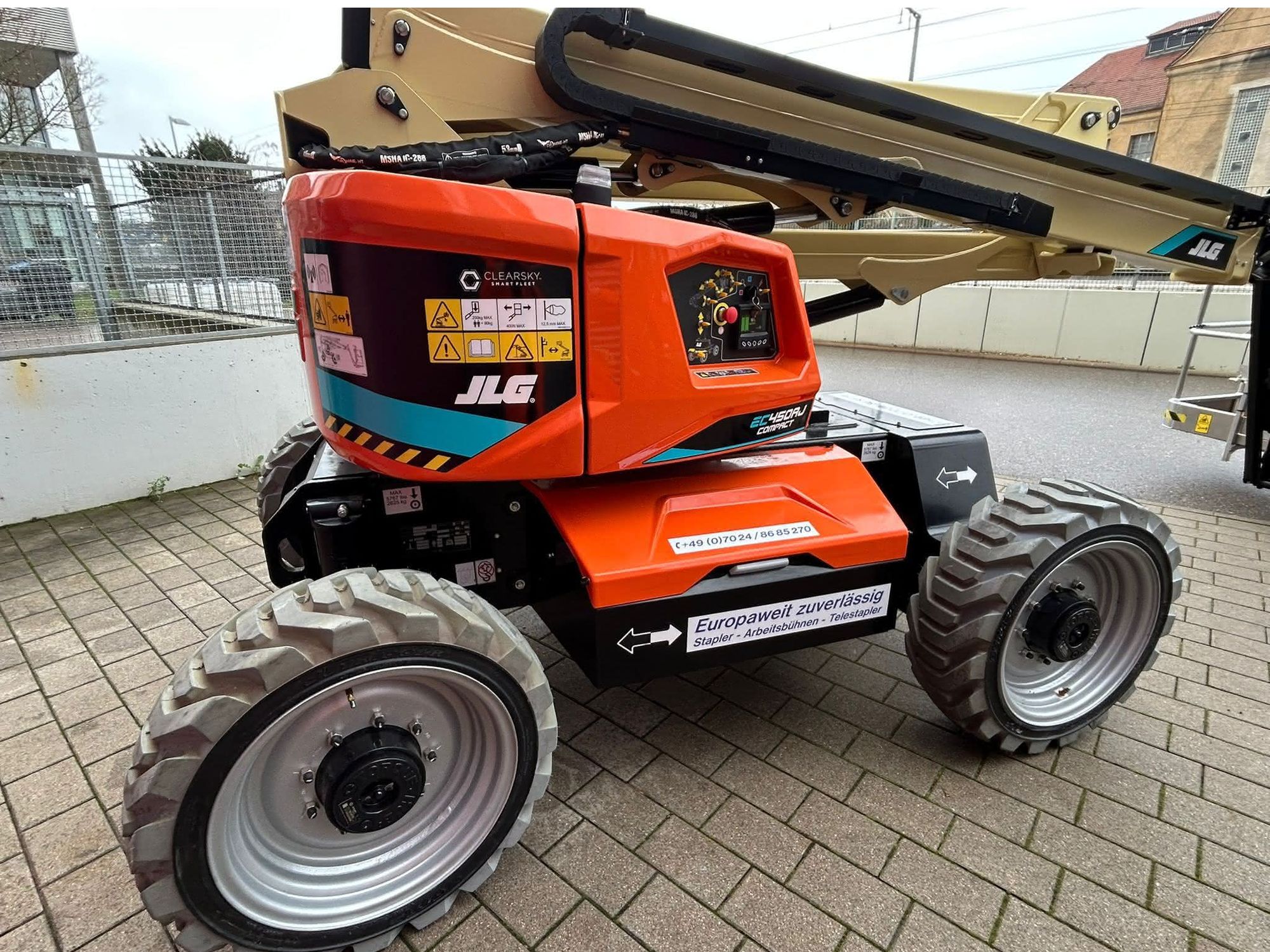 Eine neue elektrische Arbeitsbühne in roter Lackierung und im eingeklappten Zustand