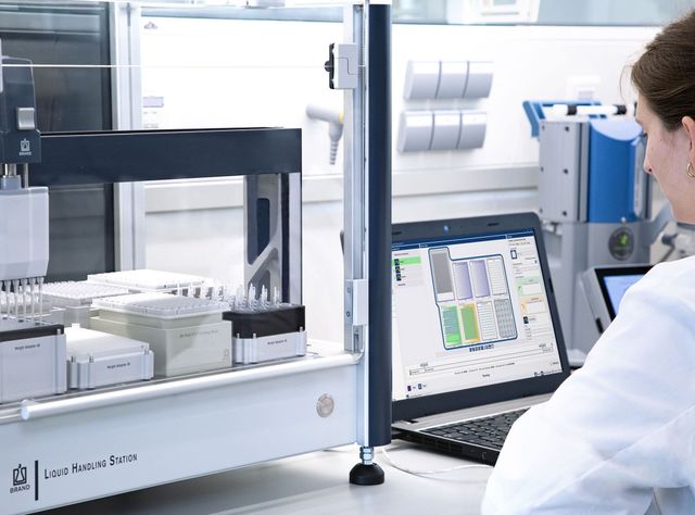 Liquid Handling Automatisiertes Tropfen abstreichen Mitarbeiterin im Labor