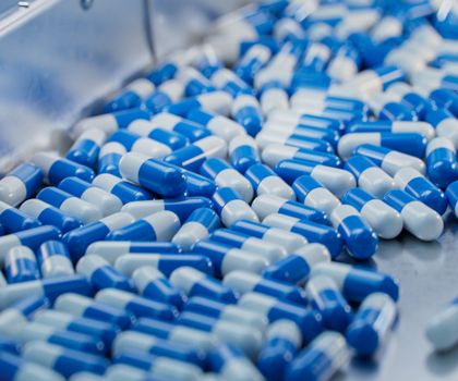 Audit-Trail-Review-Pflichten im pharmazeutischen Umfeld Kapseln auf einem Fließband in einem Herstellungsbetrieb der Pharmazeutischen Industrie