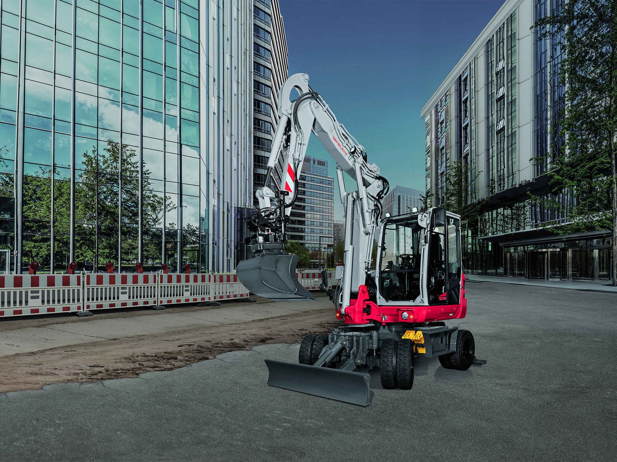 Ein neuer Takeuchi TB 370W vor mehreren Hochäusern mit Glasfassaden