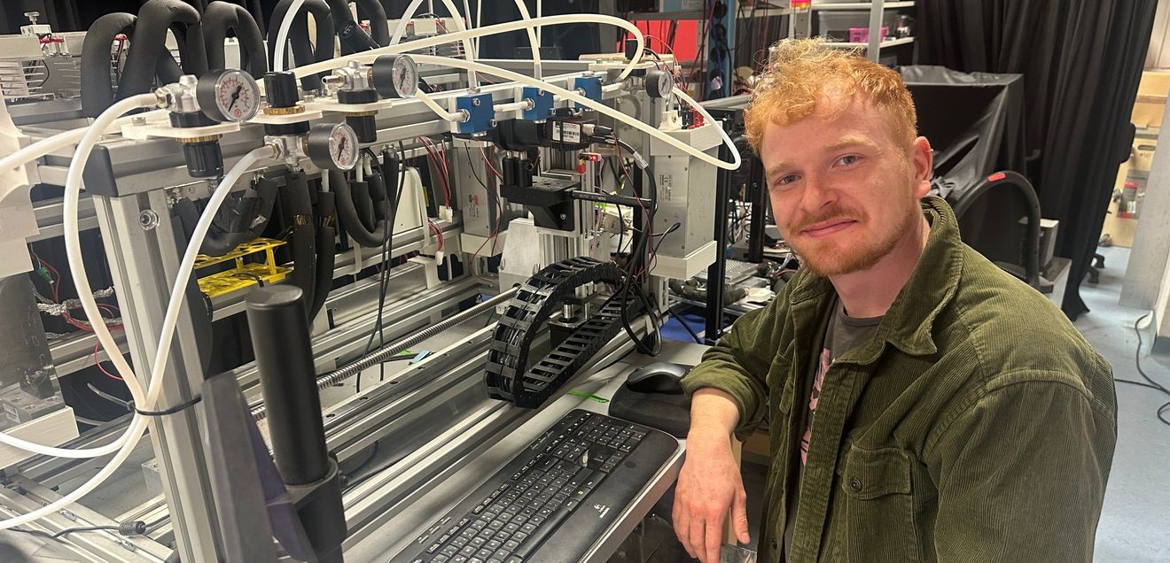 Philipp Schwintek im Labor neben einem Fluoreszenzmikroskop Philipp Schwintek im Labor neben einem Fluoreszenzmikroskop