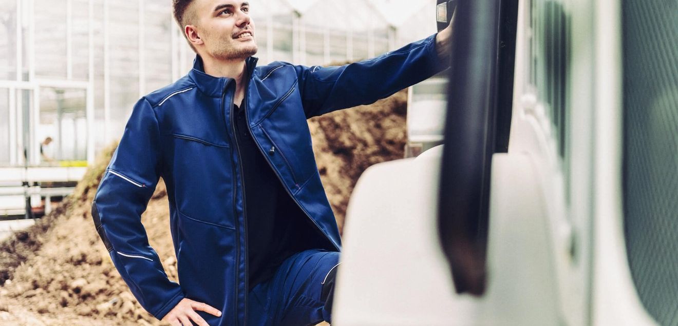 Kollektion Ein Arbeiter in blauer Arbeitskleidung von Weitblick an einer Maschine auf einer Baustelle