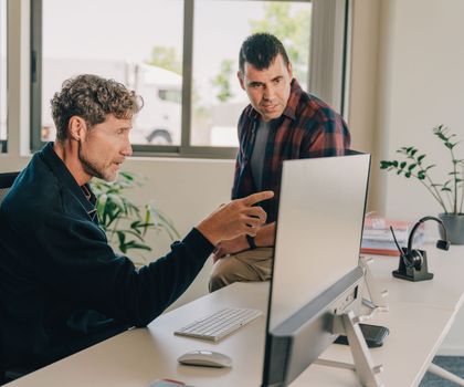 Compliance mit Webfleet Zwei männliche Mitarbeitende managen die Telematik und das Fuhrparkmanagement mit Webfleet