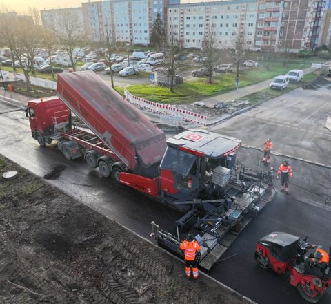 Ein Straßenfertiger im Zusammenspiel mit einem Ashpalt-Lkw