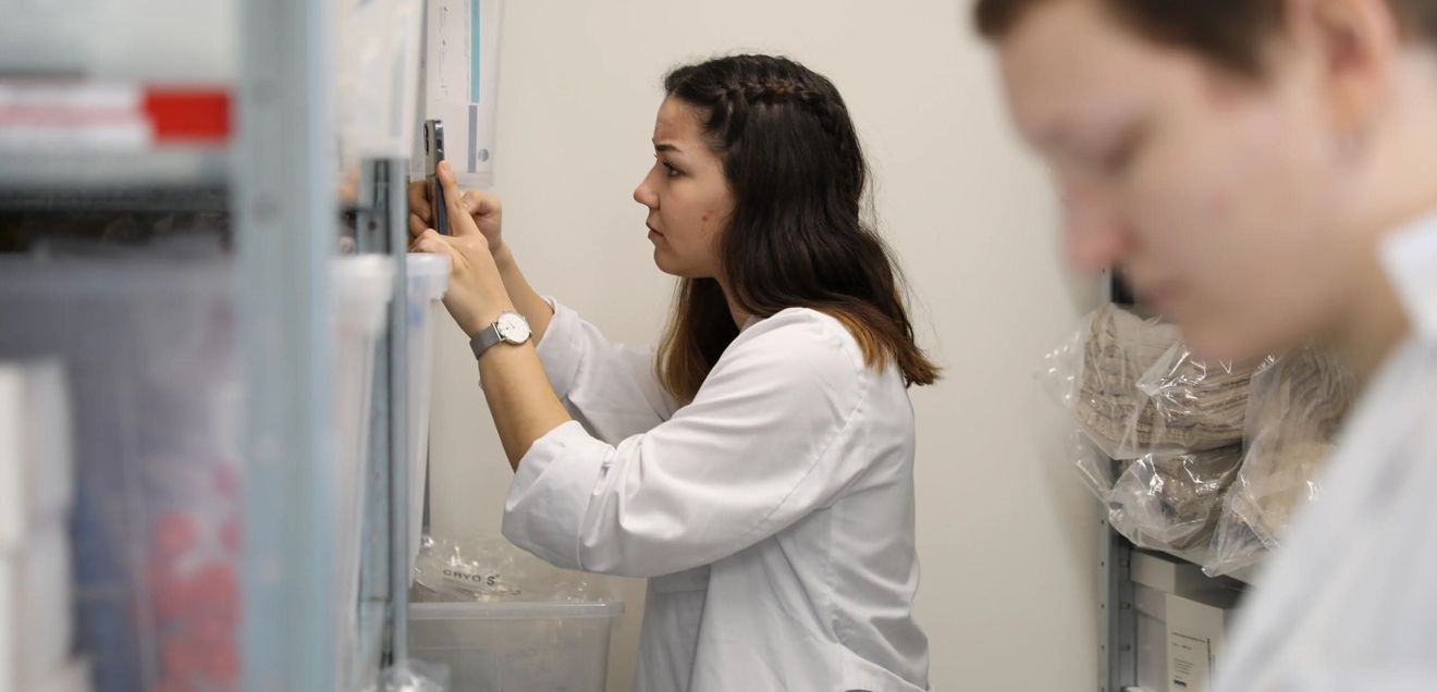 Digitalisierung im Materiallager Studierende im Ausbildungslabor bei der Digitalisierung der Laborbestände. Sie hält ein Mobiltelefon in der Hand.