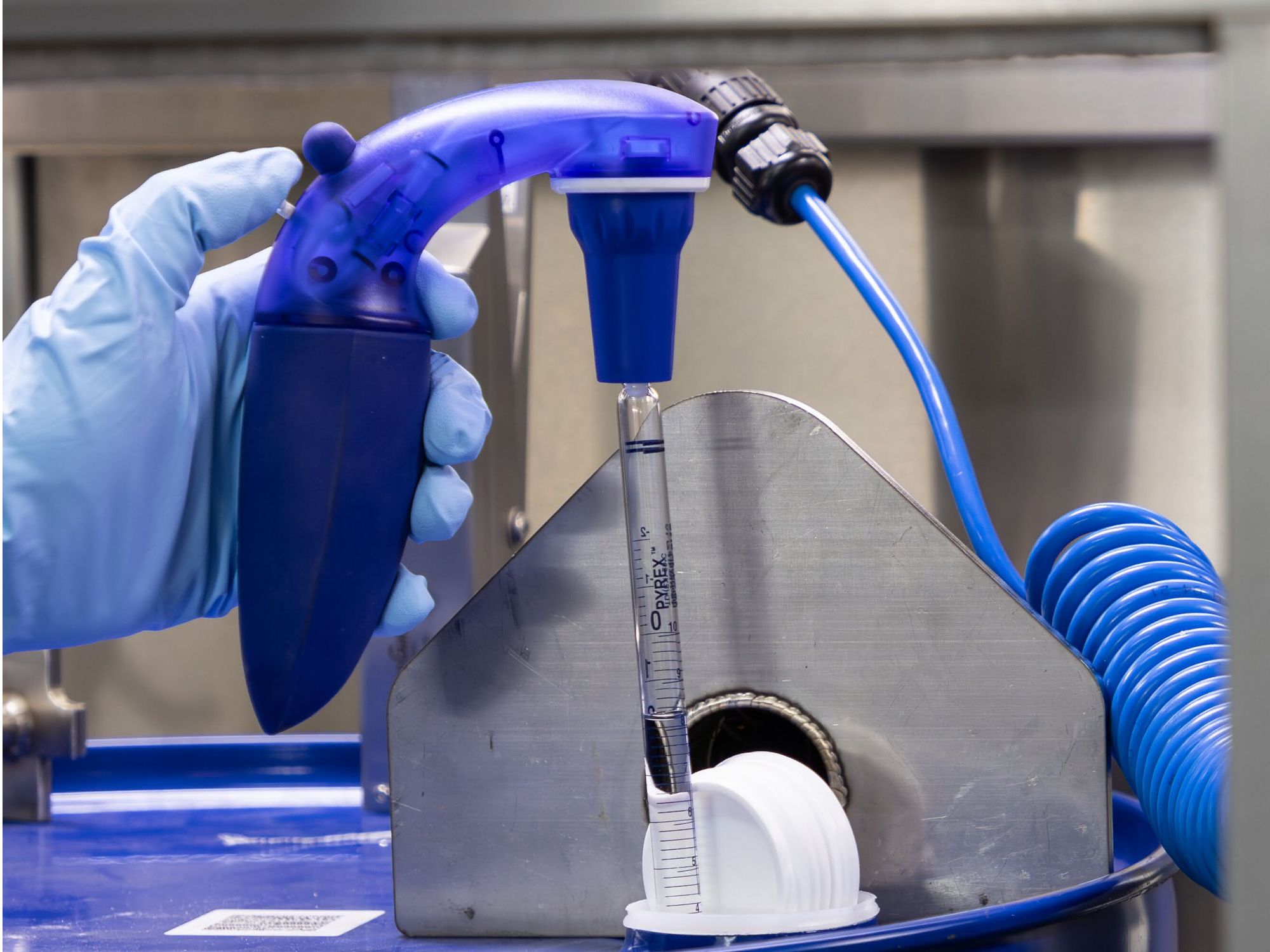 Probenahme mit spezieller Vorrichtung für Flüssigkeiten. Hand eines Labormitarbeitenden entnimmt Probe mit spezieller Vorrichtung für Flüssigkeiten.