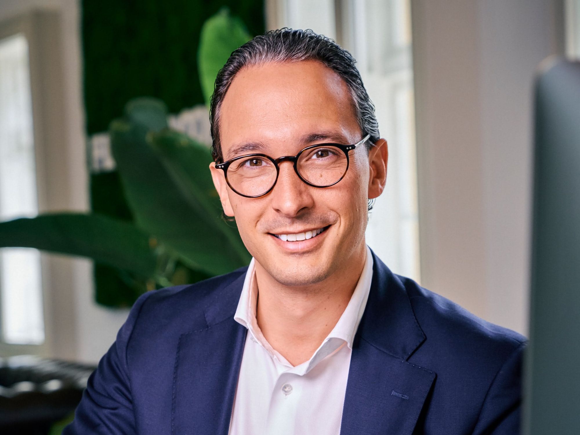 Dr. Hans-Christian Stockfisch lächelt am Schreibtisch sitzend freundlich in die Kamera