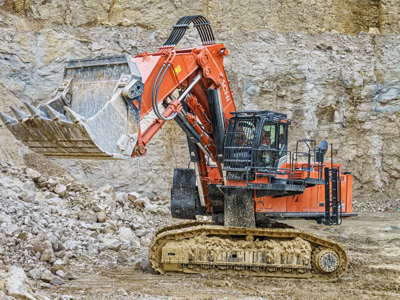 Ein Hitachi räumt im Steinbruch auf Jedem Gestein gewachsen