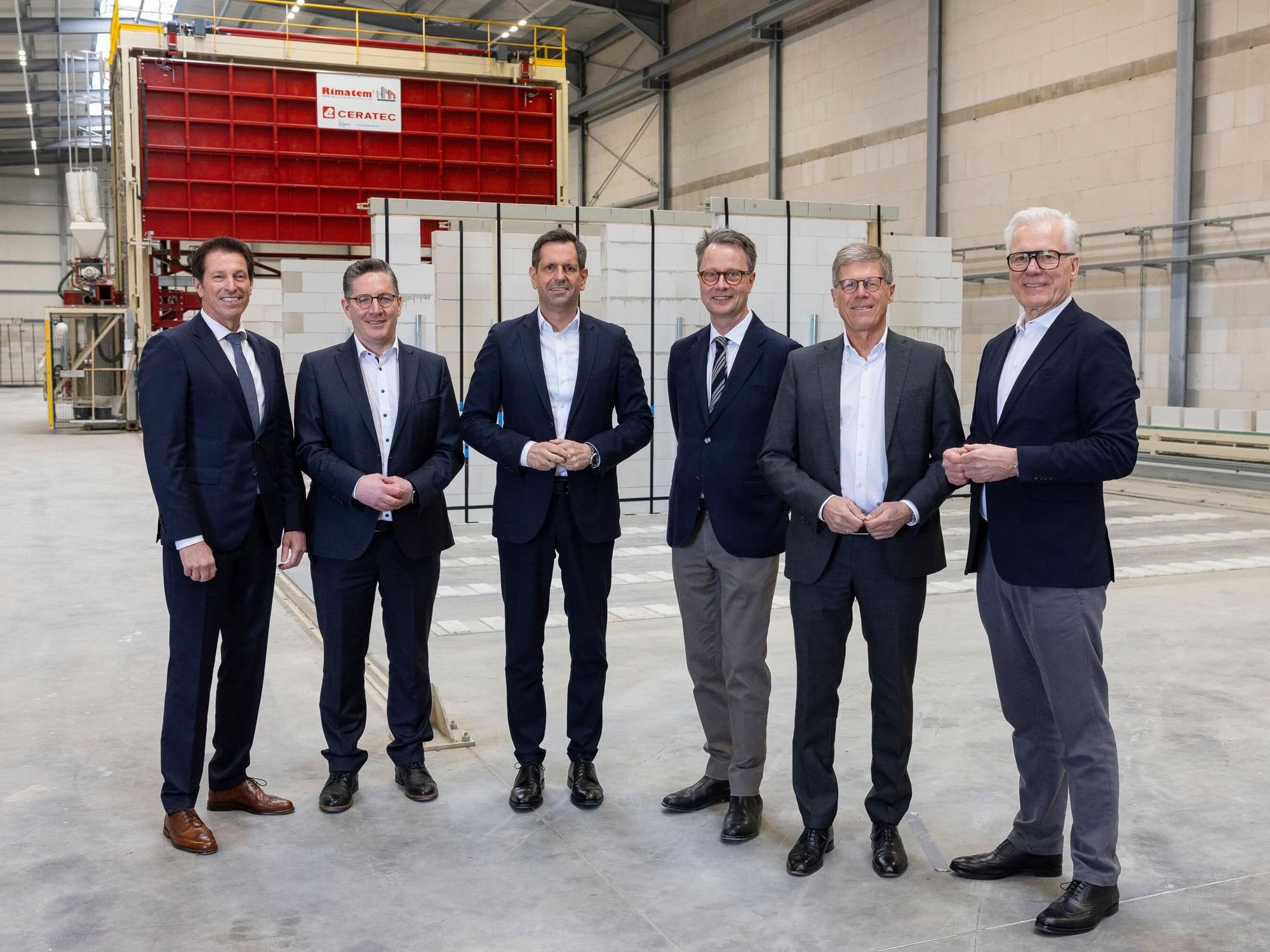 Die Vertreter von Politik und Baugewerbe beim Werksrundgang im Emsland blicken in die Kamera.