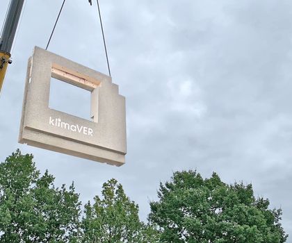 Ein vorgefertigtes Betonfertigteil wird auf die Baustelle gehoben.