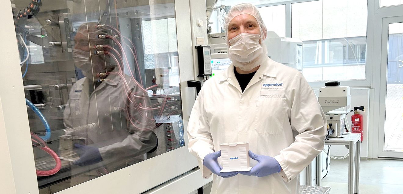 Einweg-Rack aus Rezyklat Eppendorf-Mitarbeiter zeigt Einweg-Rack aus Rezyklat