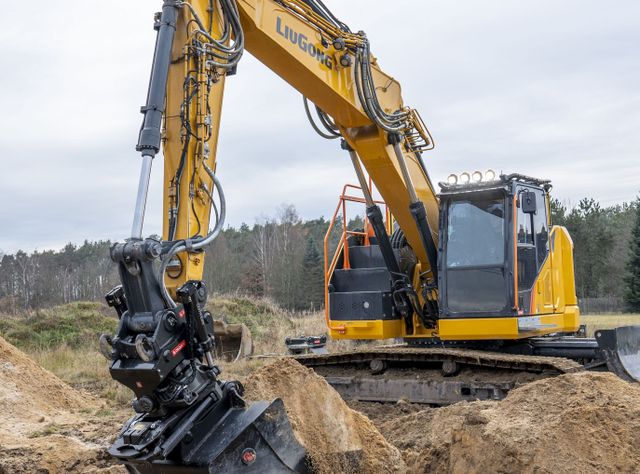 LiuGong mit neuen Baggern und Radladern Ein gelber Bagger von LiuGong auf einer Baustelle in einem Wald