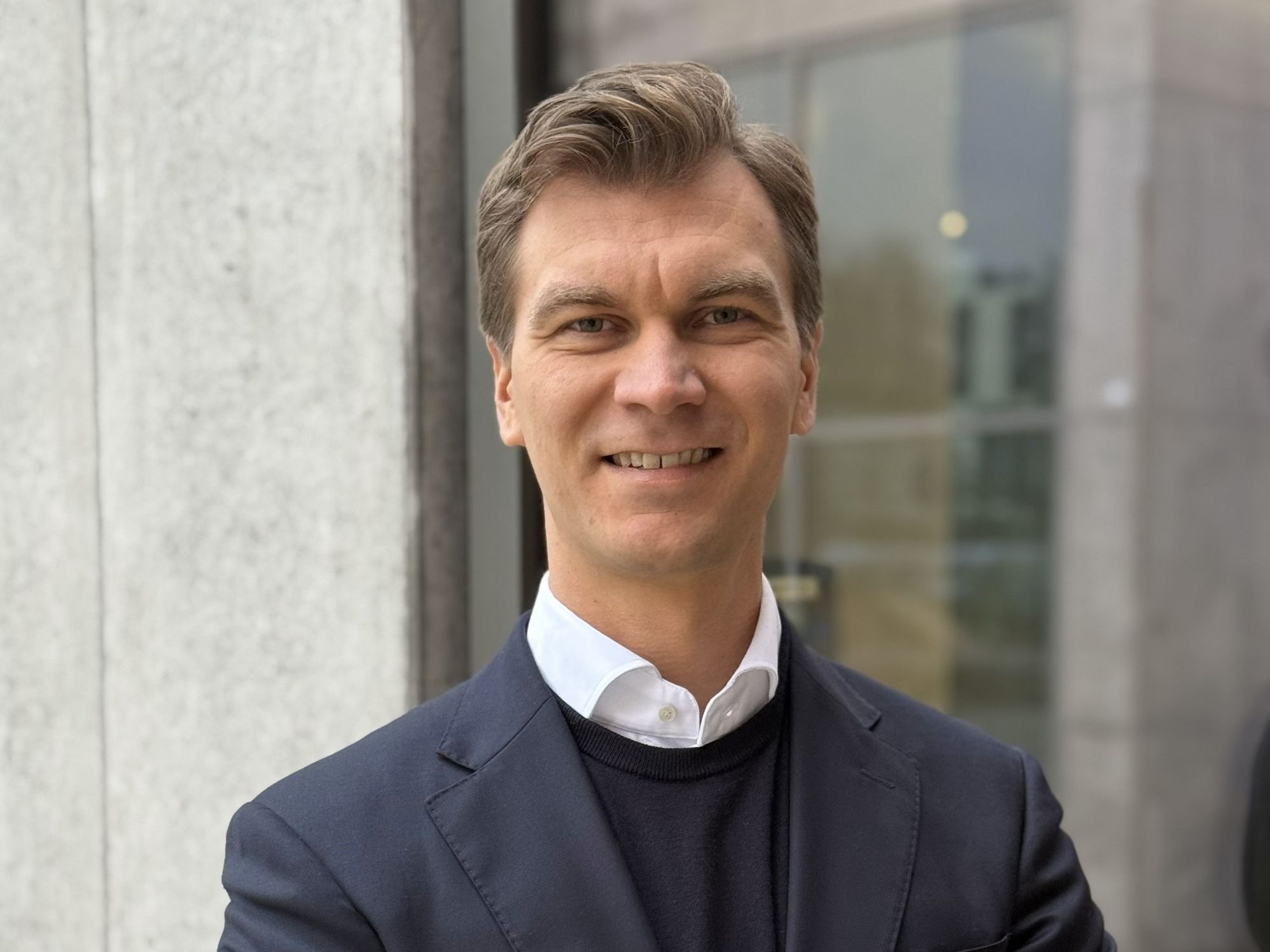 Markus Hlawatsch (36) ist neuer Chief Operating Officer von Doka Deutschland und lächelt mit verschränkten Armen in die Kamera