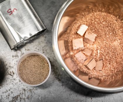CO₂-freie Zinngewinnung: TU Freiberg entwickelt klimafreundliches Verfahren Die Versuche in Laborskala wurden mit Zinn-Konzentrat in Pulverform durchgeführt. Hier zu sehen: Verschiedene Metalle in kleinen Tiegeln.