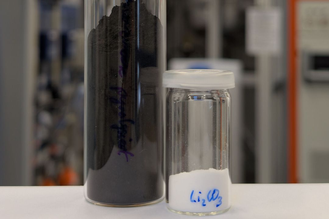 Zwei Glasgefäße: Eines enthält Schwarzmasse und das zweite weißes Lithiumcarbonat