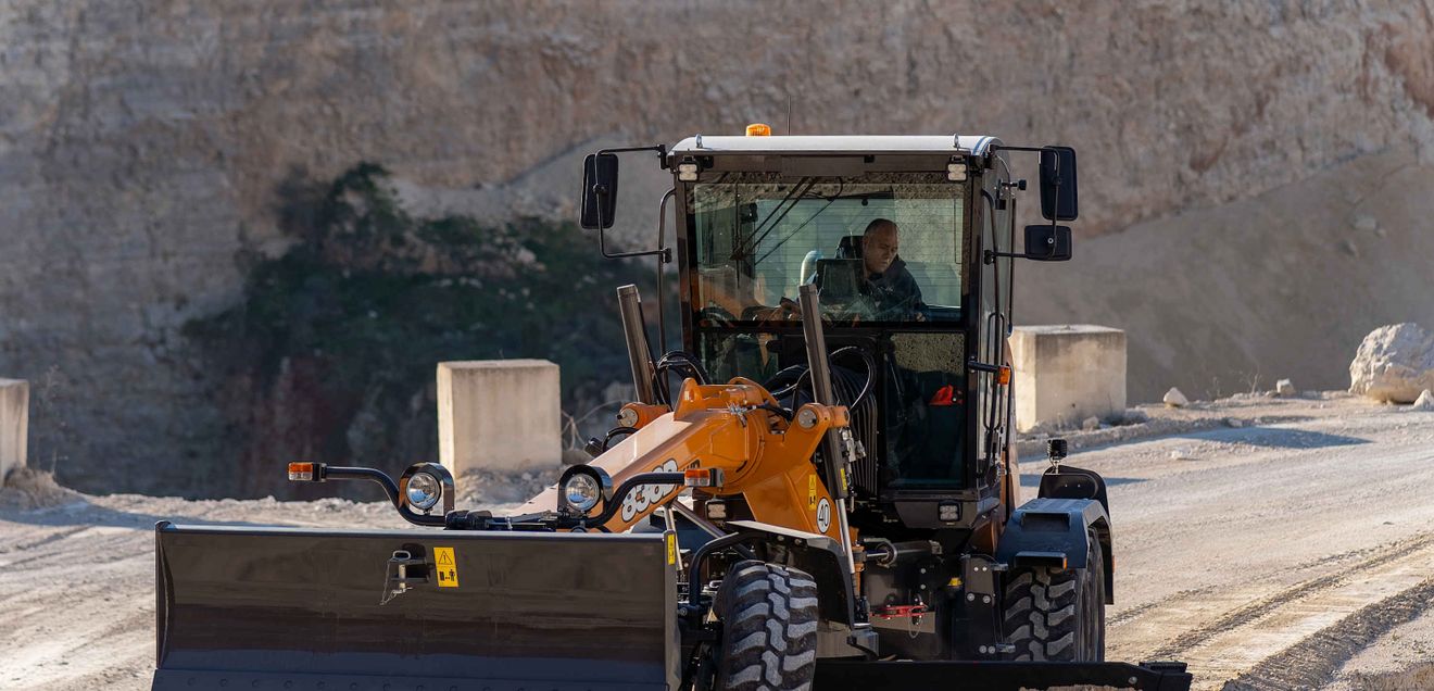 Ein Fahrer glättet mit einem neuen Case Grader den Schotterboden eines Steinbruchs