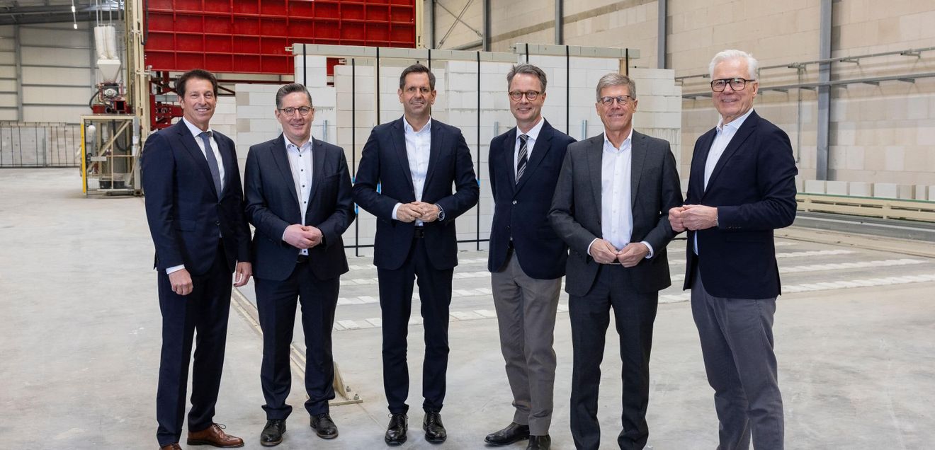 Rundgang Die Vertreter von Politik und Baugewerbe beim Werksrundgang im Emsland blicken in die Kamera.