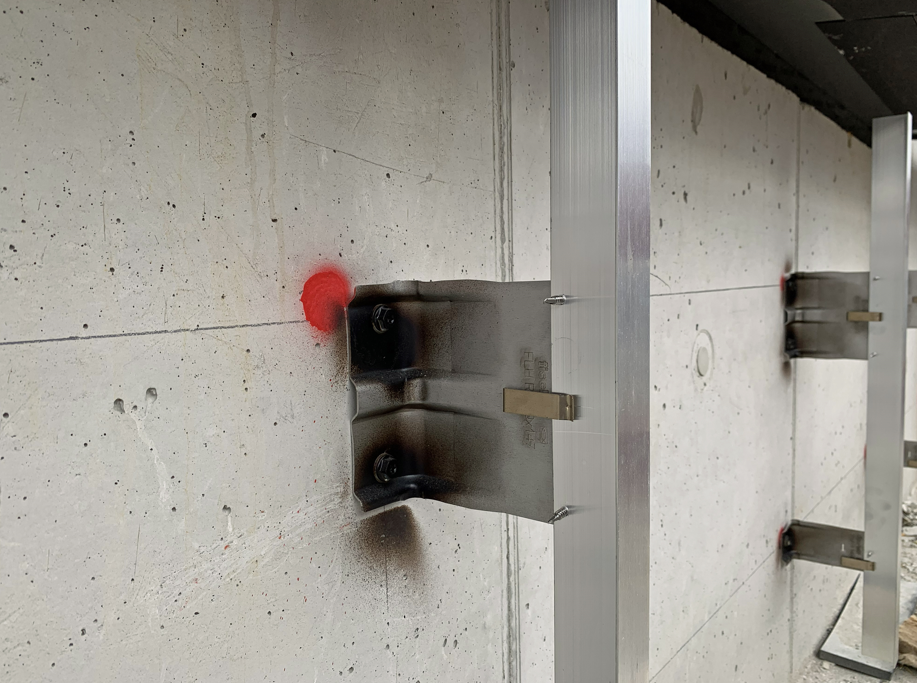 fischer Unterkonstruktionssystem für die PV-Fassade: Edelstahl-Wandhalter FLH R, T-Profile sowie die Tragprofile ATK 103 P20 und ATK 103 V bilden eine wärmebrückenarme, zugelassene und montagefreundliche Basis für die Solarwatt vision GM 3.0 construct Module.