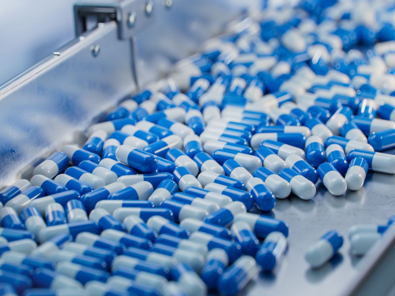 Audit-Trail-Review-Pflichten im pharmazeutischen Umfeld Kapseln auf einem Fließband in einem Herstellungsbetrieb der Pharmazeutischen Industrie