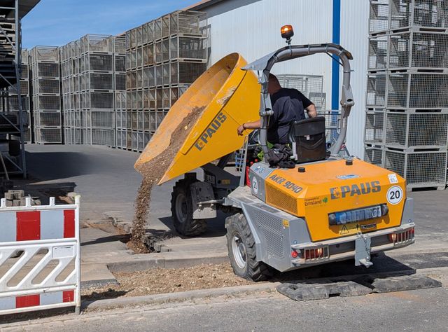 Ein gelber Paus Dumper, der seine Mulde nach links ablädt