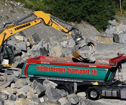 Ein Meiller Grandload Kippsattelanhänger wird mit Steinen beladen Ein Meiller Grandload Kippsattelanhänger wird mit Steinen beladen