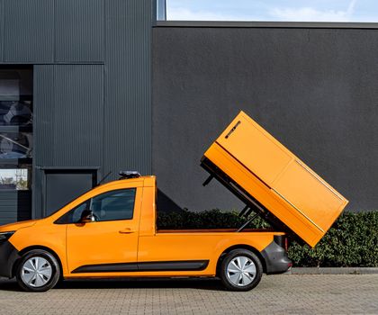 Ein Nissan Townstar EV mit oranger Lackierung und aufgestelltem Aufbau