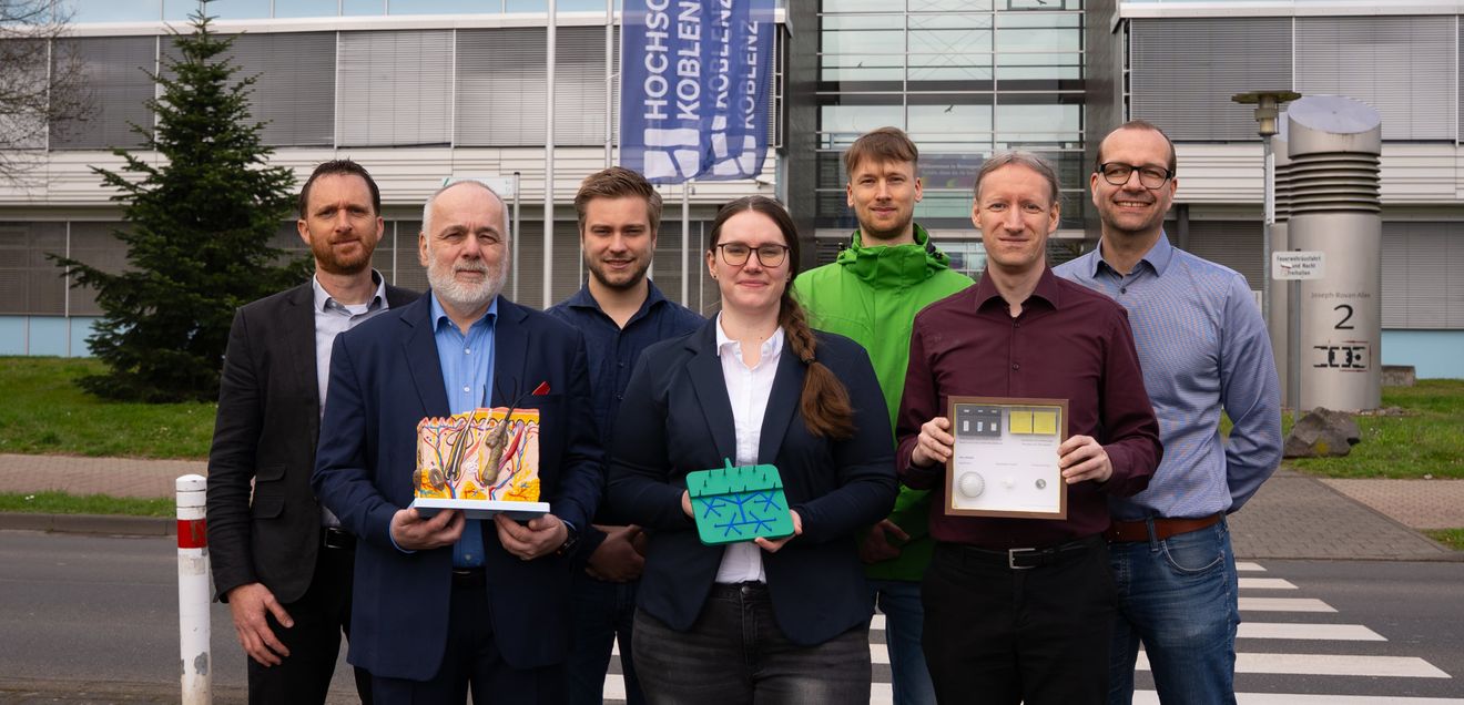 Biomarker minimalinvasiv messen: Hochschule Koblenz entwickelt Mini-Labor für die Haut Die Beteiligten der Forschungsgruppe zeigen modellhaft einen Querschnitt durch die Haut, ein vergrößertes Mikronadelpatch sowie Modelle der Patches in Originalgröße.