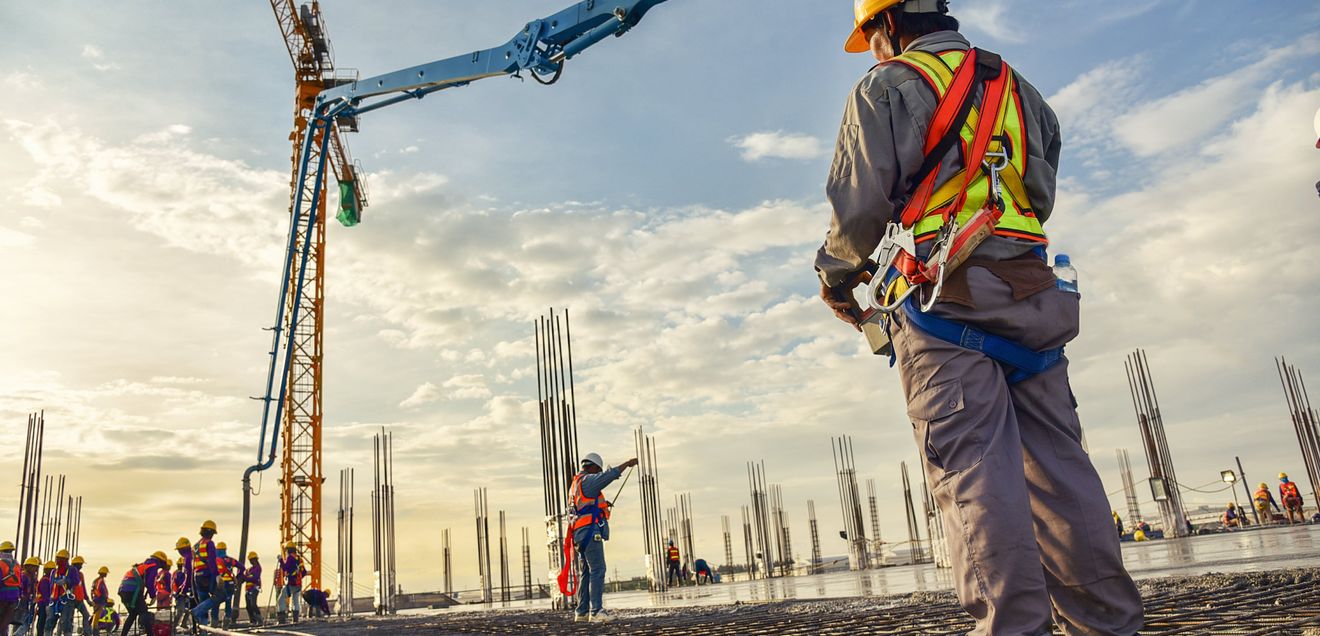 Digitalisierung Ein Arbeiter auf einer Baustelle steuert einen Kran per Fernsteuerung