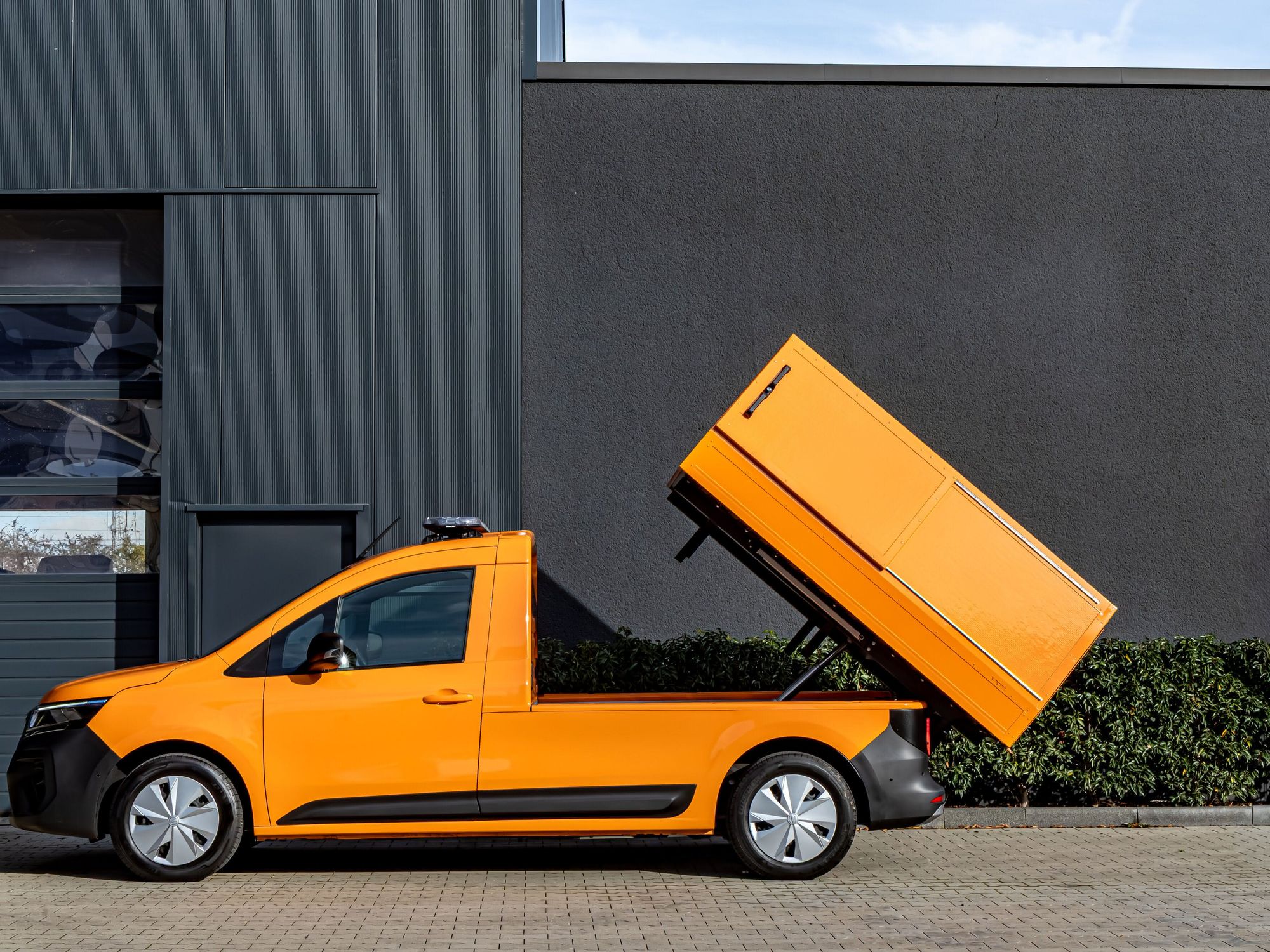Ein Nissan Townstar EV mit oranger Lackierung und aufgestelltem Aufbau