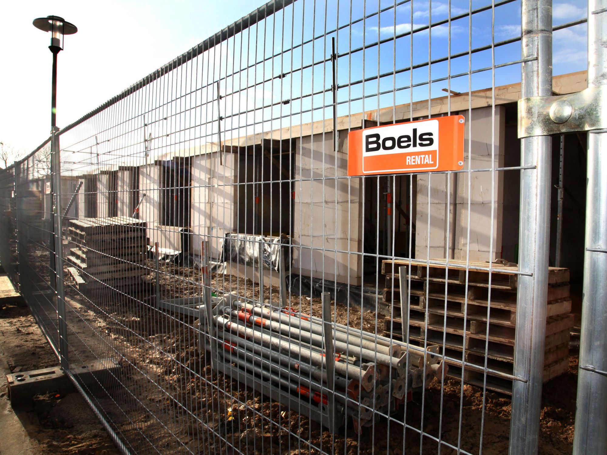 Ein Bauzaun von Boels Rental, der eine Baustelle sichert.
