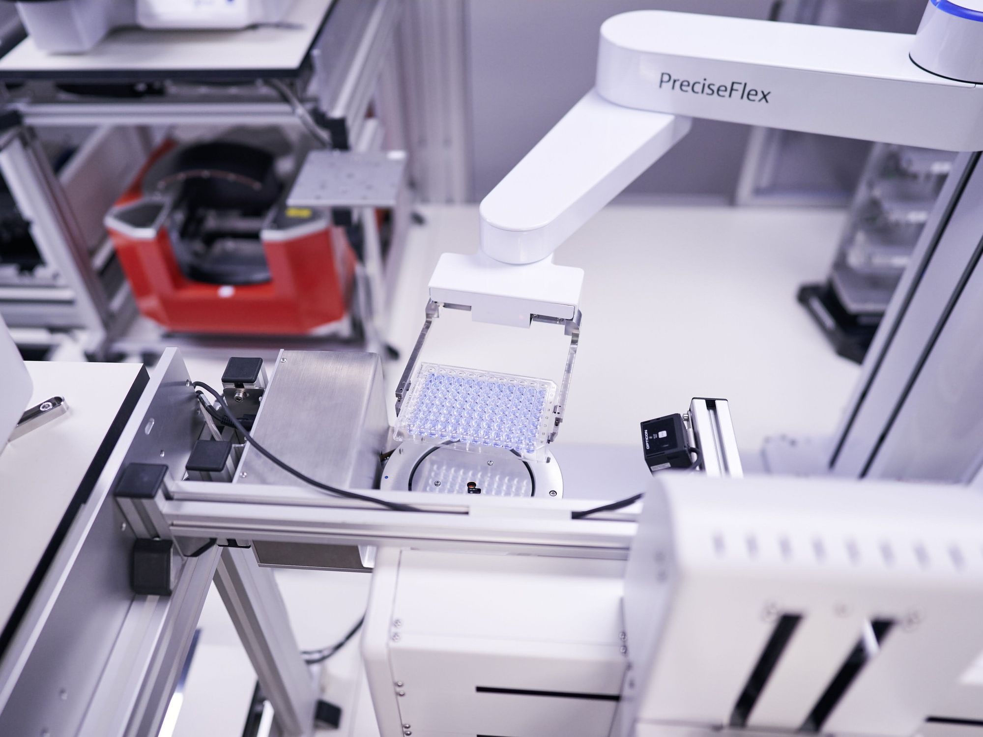 Roboterarm transportiert eine Mikrotiterplatte