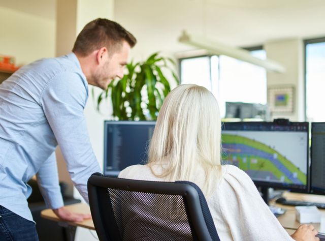 Materialfluss Ein männlicher und ein weiblicher Mitarbeiter prüfen die Logistik auf einem Computerbildschirm