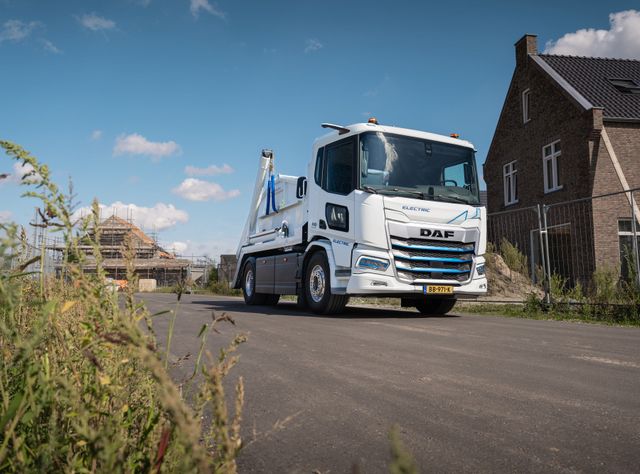 Ein Bau-Lkw von DAF Trucks in Weiß, der beladen eine Baustelle verlässt
