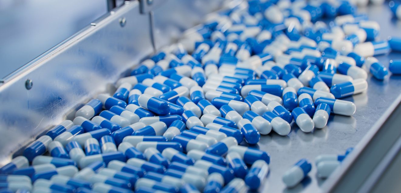 Audit-Trail-Review-Pflichten im pharmazeutischen Umfeld Kapseln auf einem Fließband in einem Herstellungsbetrieb der Pharmazeutischen Industrie
