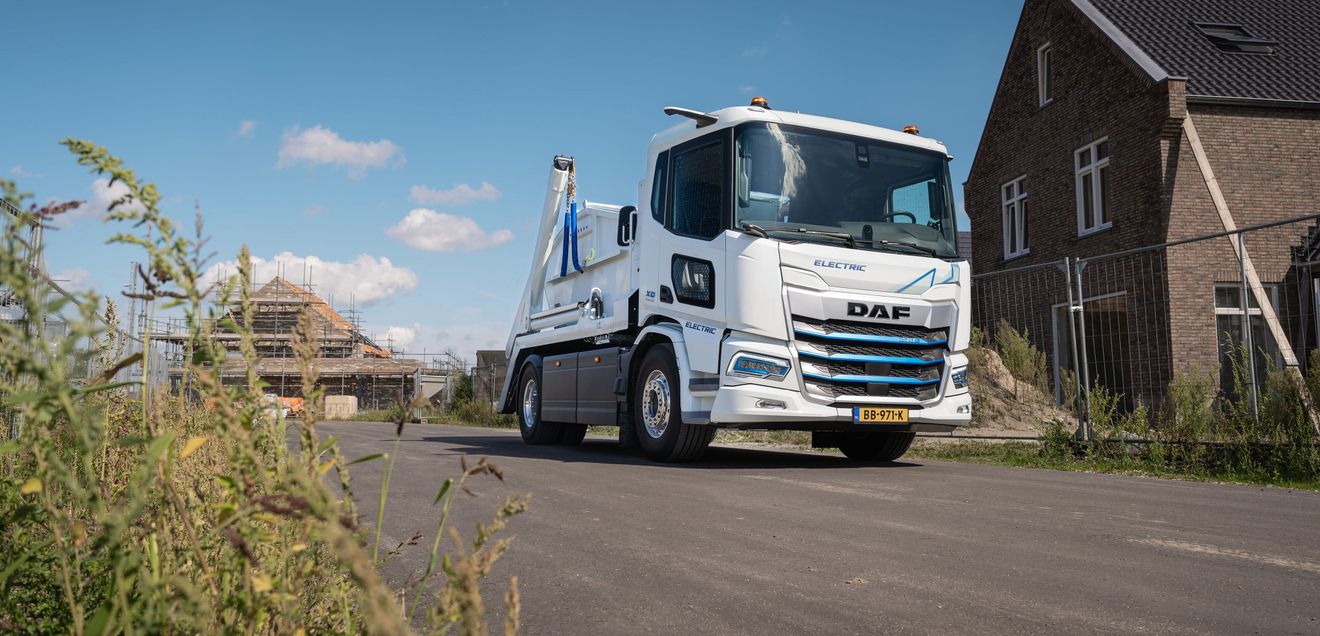 DAF Trucks Ein Bau-Lkw von DAF Trucks in Weiß, der beladen eine Baustelle verlässt